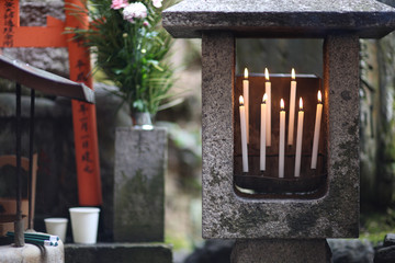 Candles burn in a place of worship to the deity in the territory Shrine