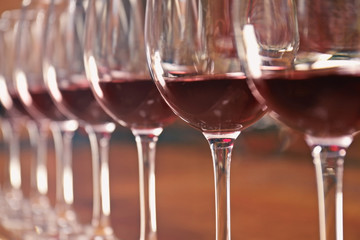 Row of glasses with red wine on bar counter, closeup