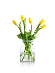 Glass vase with bouquet of beautiful tulips on light background