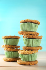 Tasty kiwi ice cream cookie sandwiches on wooden table