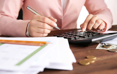 Woman sitting at table with calculator