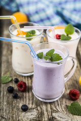 Smoothies or yogurt with fresh berries on a wooden table.