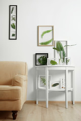 Frames with green leaves in interior on white background
