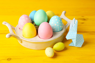 Easter bunny with colorful eggs on wooden table