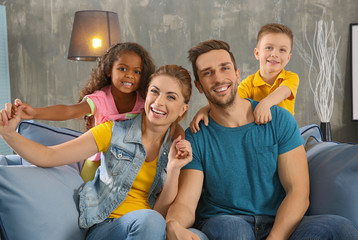 Happy interracial family sitting on sofa