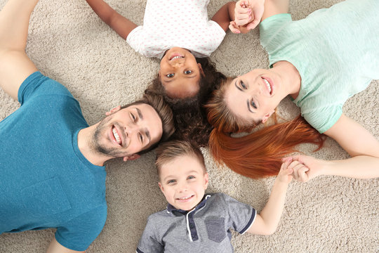 Happy interracial family lying on floor