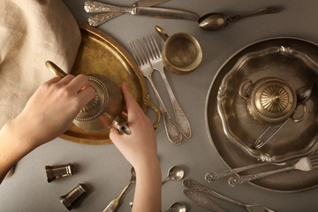Composition with vintage tableware and female hands holding teapot