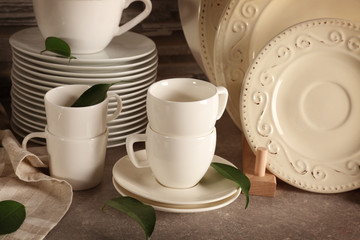 Composition with rustic dinnerware and green leaves