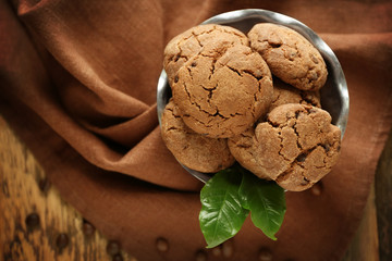 Bowl with delicious cookies on brown napkin