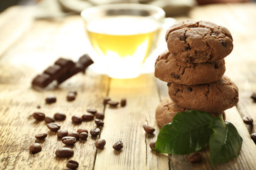 Pile of delicious cookies and cup of tea on wooden table