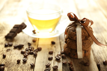 Pile of delicious cookies and cup of tea on wooden table