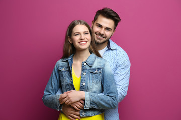 Cute young couple on color background