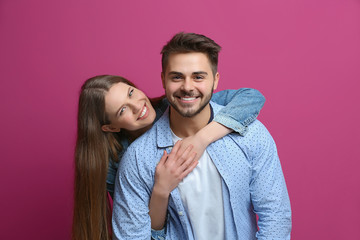 Cute young couple on color background