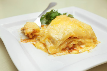 Plate with tasty lasagna on table