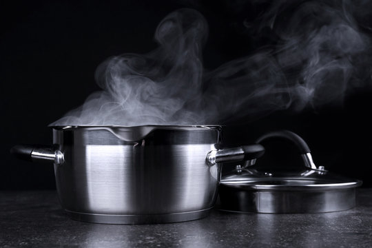 Pan with steam on dark background