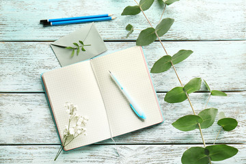 Opened diary and flowers on wooden table