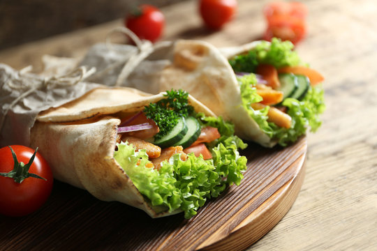 Delicious kebab sandwiches on wooden board