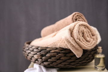 Fototapeta na wymiar Spa towels in wicker basket on dark background