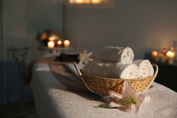 Fototapeta na wymiar Spa towels in wicker basket on massage table
