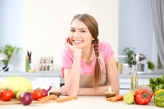 Young woman with different vegetables at kitchen
