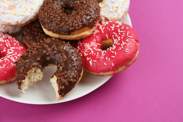 Tasty glazed donuts on color background