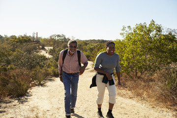 Mature Couple Hiking Outdoors In Countryside Together