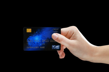 Hand holding credit card on black background