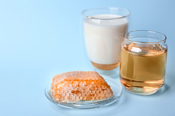 Composition with milk, honey and honeycomb on blue background