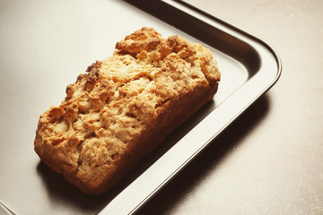 Tasty loaf of beer bread in baking tray on table