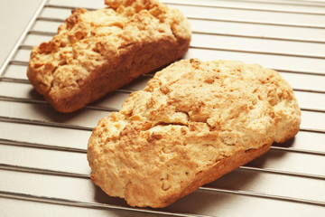 Tasty loafs of beer bread on metal grid