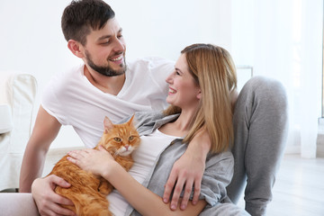 Happy couple with cat at home