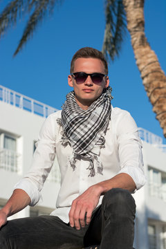 Man in sunglasses and in a keffiyeh in summer time