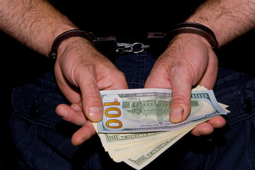 Cash money in the hands of which handcuffed.