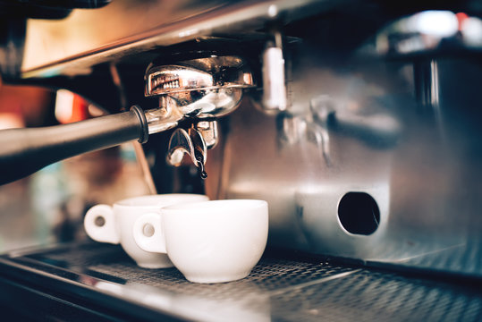 Professional coffee brewing. Espresso machine preparing and pouring two perfect cups of coffee. Restaurant details