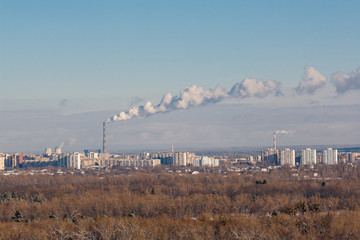 Winter town. Frosty sunny day in the city. Snow on the streets and smoke from the boiler rises....