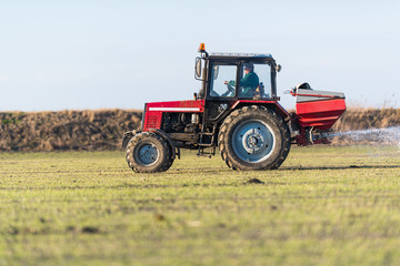 Obraz premium Tractor spreading artificial fertilizers