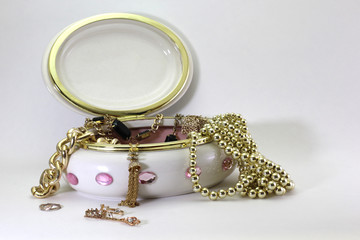 A photograph of a jewelry box with gold jewelry spilling out.