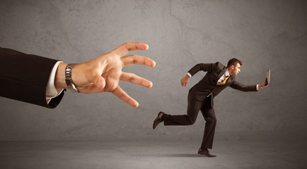 Businessman running from hand
