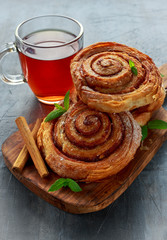 Freshly Baked Traditional Sweet Cinnamon Rolls, Swirl with hot black Tea and mint