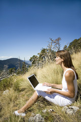femme avec son ordinateur dans la nature 