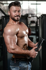 Fototapeta na wymiar Brutal strong bodybuilder man pumping up muscles and train gym