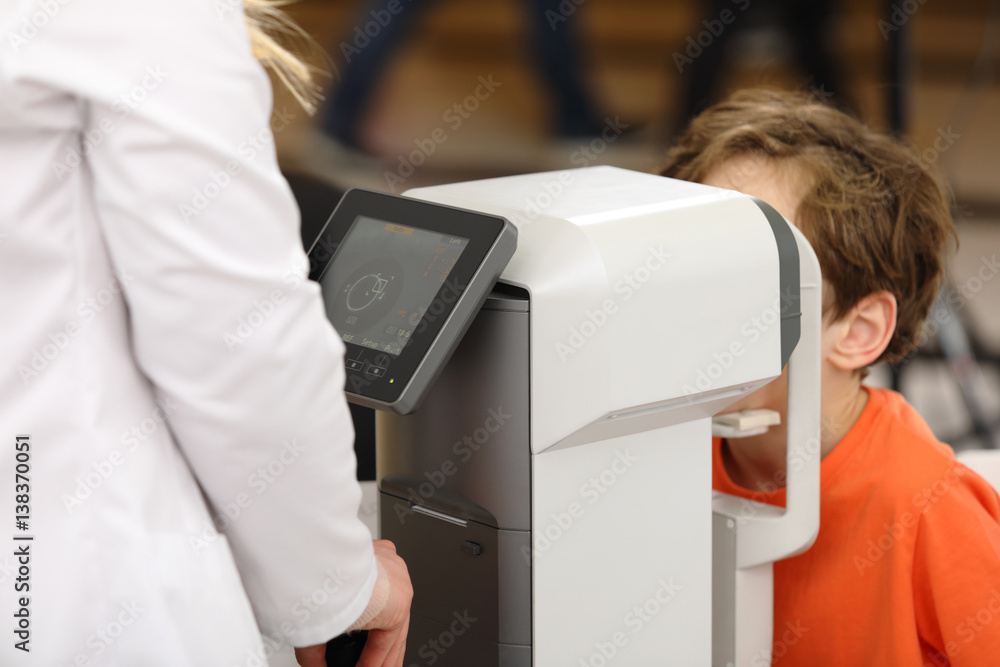 Poster eye examination, optometrist in exam room with young boy