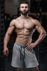 Obraz na płótnie Canvas Handsome fitness model train in the gym gain muscle.
