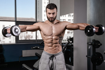 Fototapeta na wymiar Handsome fitness model train in the gym gain muscle.