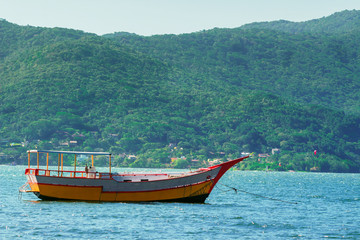 Wooden boat in the middle of the sea arm in a blue day