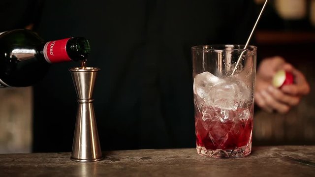 Bartender adding vermouth to cocktail