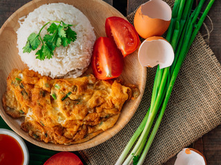 Vintage style Thai traditional food quick and common omelet with rice on top with wooden background wallpaper