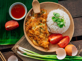 Vintage style Thai traditional food quick and common omelet with rice on top with wooden background wallpaper