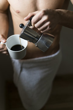 Attractive young man with six pack drinking coffee