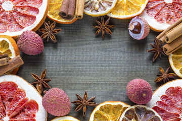Lychee fruits with citrus slices and sspices on wooden background